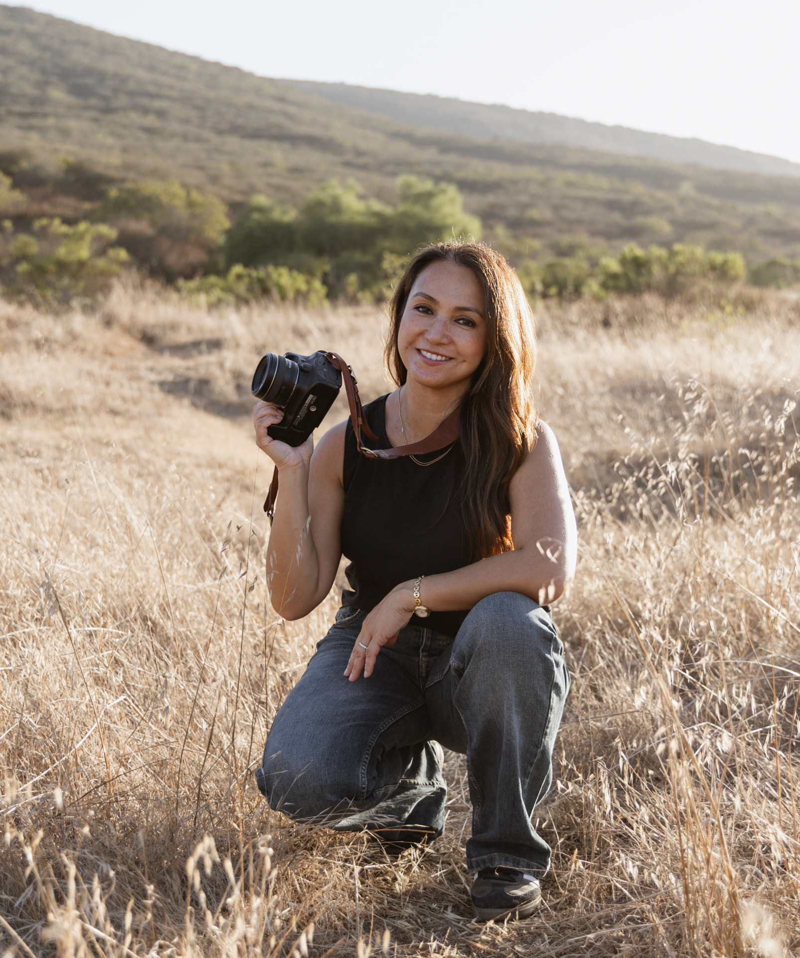 Portrait of photographer Emmylou Soriano holding her camera