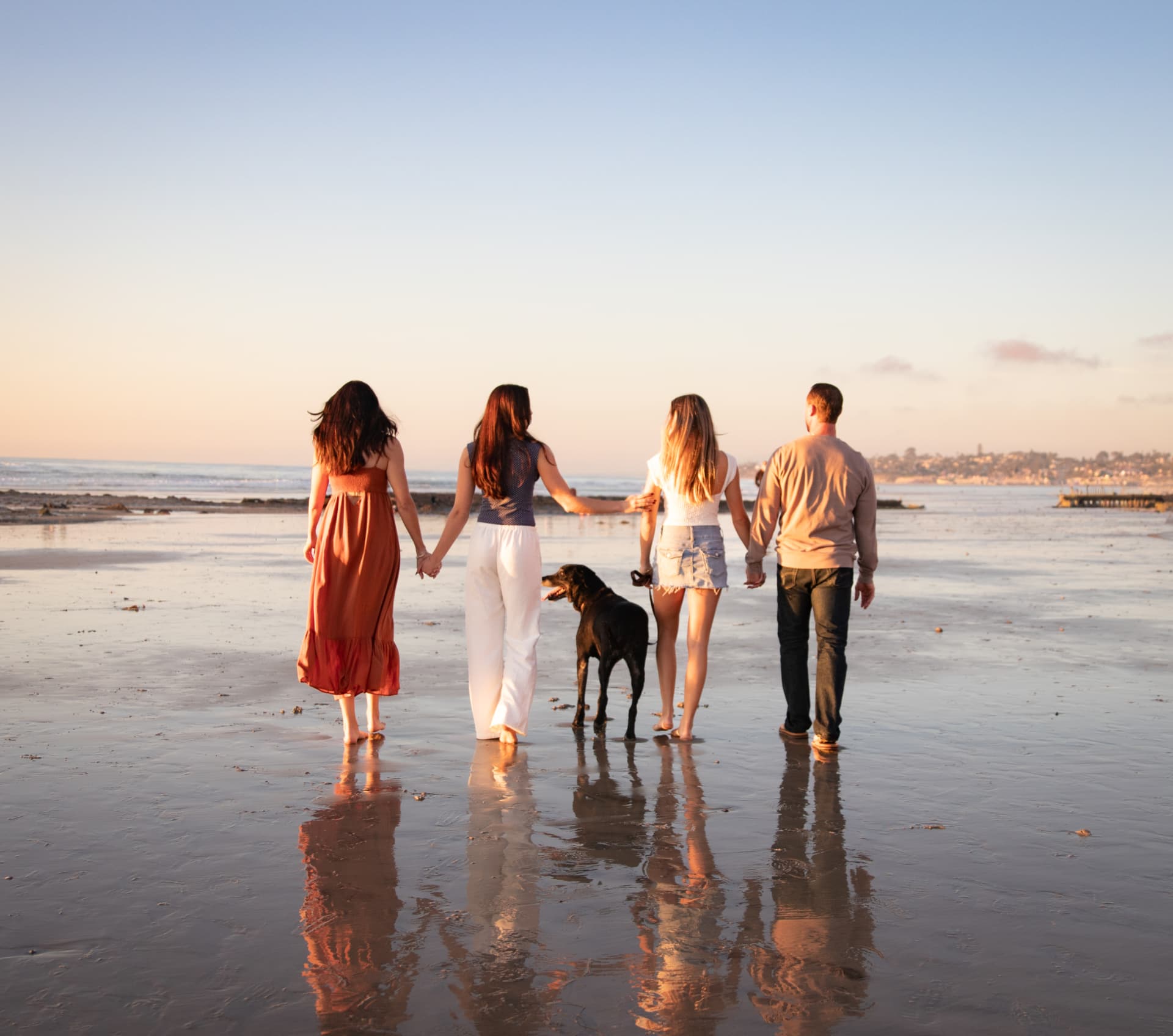 Family walking together on a golden beach at sunset